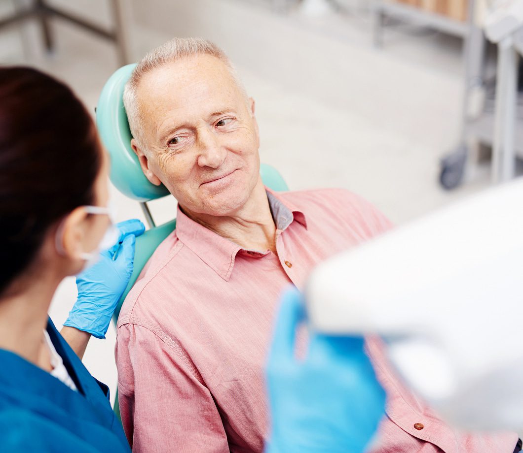 Older patient chatting with a clinician before his procedure